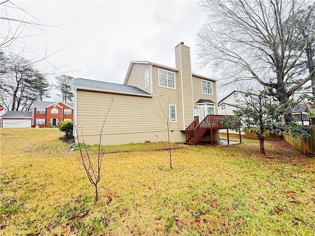 back of house with stairway, a lawn, a chimney, and fence