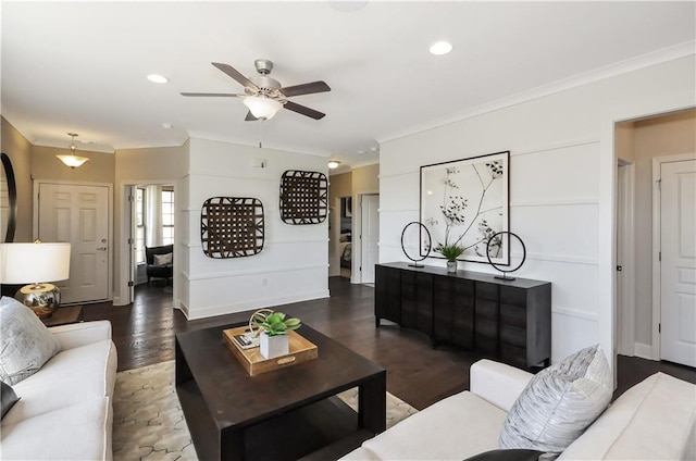 living room featuring dark hardwood / wood-style floors, ceiling fan, and ornamental molding