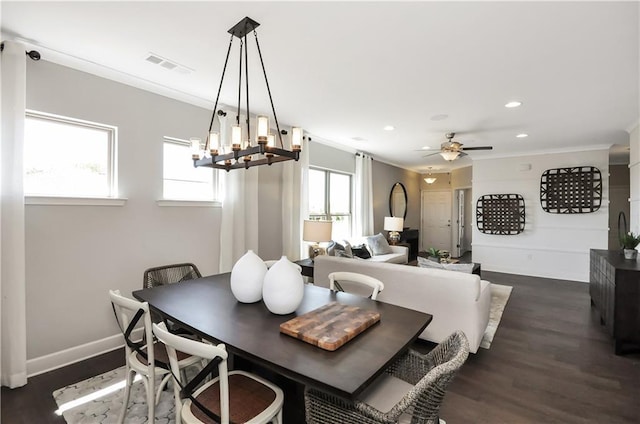 dining room with dark hardwood / wood-style flooring, a healthy amount of sunlight, and ceiling fan with notable chandelier