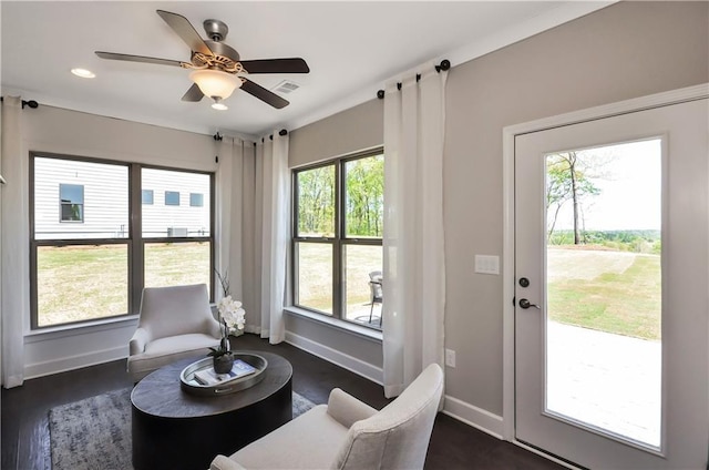 sitting room with ceiling fan and dark wood-type flooring