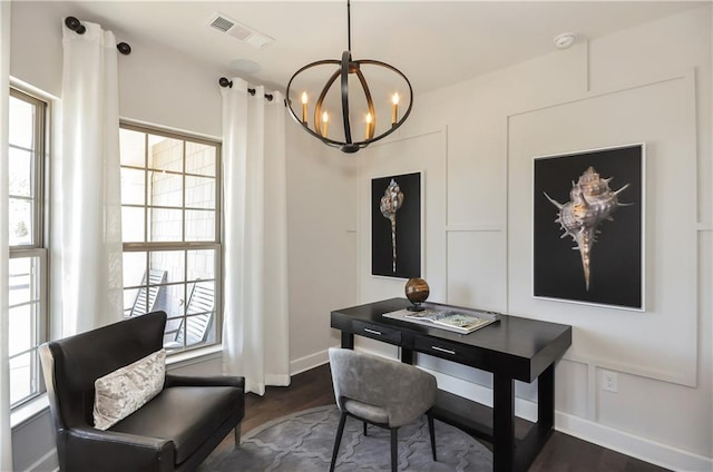 home office with dark hardwood / wood-style flooring and a notable chandelier