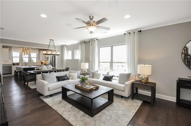 living room with hardwood / wood-style floors, ceiling fan with notable chandelier, and ornamental molding