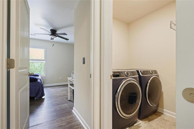 laundry room featuring wood finished floors, separate washer and dryer, baseboards, and ceiling fan