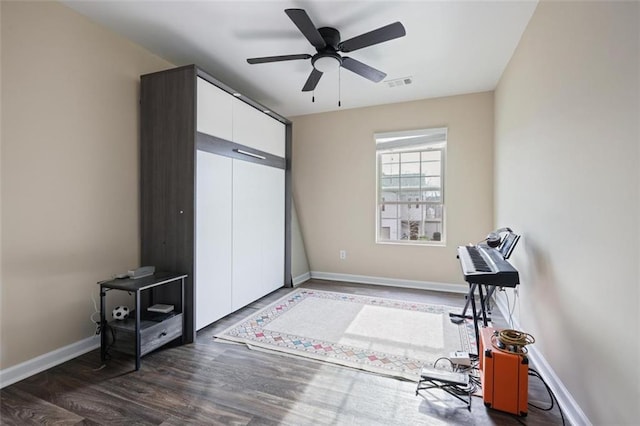 interior space featuring visible vents, ceiling fan, baseboards, and wood finished floors