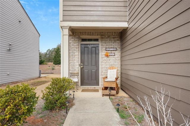 doorway to property featuring brick siding