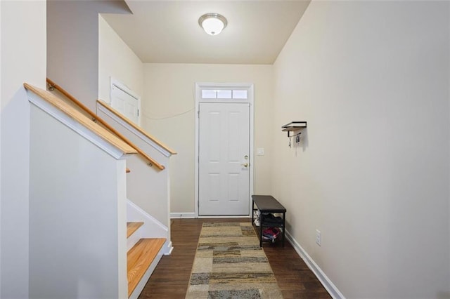 entryway with baseboards, wood finished floors, and stairs