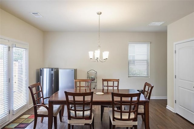 dining room featuring dark wood finished floors, baseboards, visible vents, and a chandelier