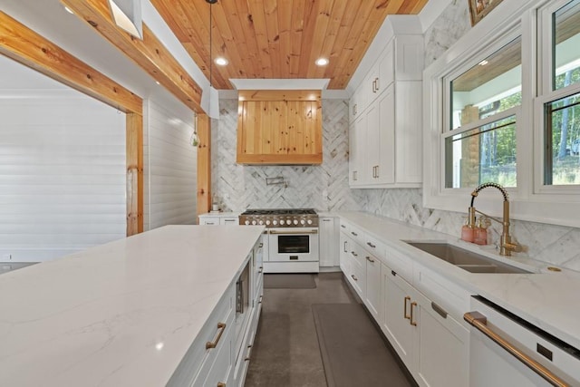 kitchen with dishwashing machine, sink, white cabinetry, hanging light fixtures, and range with two ovens