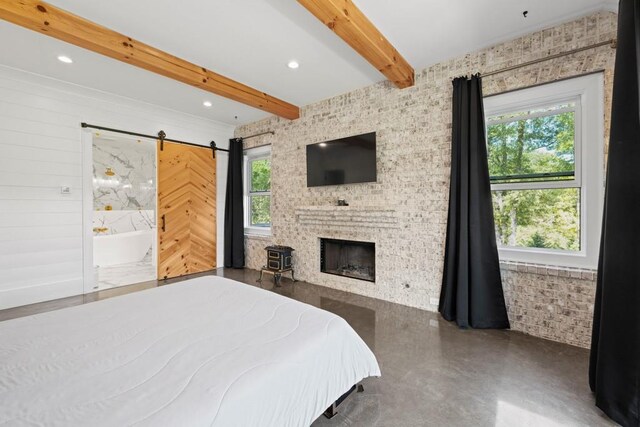 bedroom featuring beamed ceiling, a barn door, and a brick fireplace