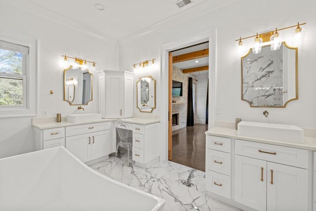 bathroom featuring vanity, a fireplace, and a bathtub