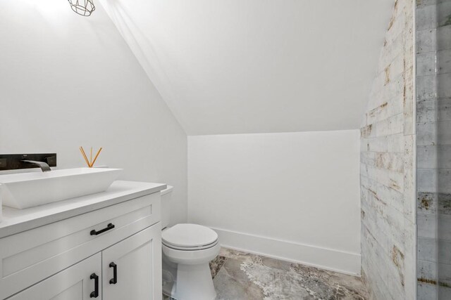 bathroom with vanity, toilet, and vaulted ceiling