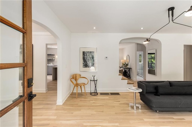 1327 Harvard Rd NE, Atlanta, GA 30306 - living room featuring light wood-style floors, baseboards, recessed lighting, arched walkways, and stairs
