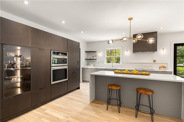 1327 Harvard Rd NE, Atlanta, GA 30306 - kitchen featuring open shelves, a kitchen breakfast bar, light countertops, stainless steel double oven, and recessed lighting