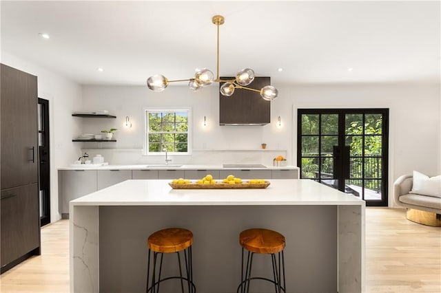 1327 Harvard Rd NE, Atlanta, GA 30306 - kitchen with modern cabinets, a sink, light wood-style flooring, a kitchen bar, and light countertops