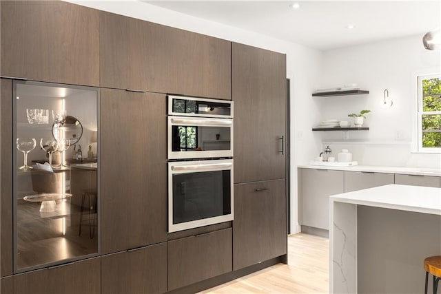1327 Harvard Rd NE, Atlanta, GA 30306 - kitchen with stainless steel double oven, light countertops, light wood-type flooring, open shelves, and modern cabinets