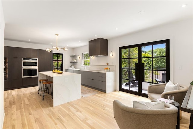 1327 Harvard Rd NE, Atlanta, GA 30306 - kitchen with modern cabinets, a kitchen island, double oven, light wood-style floors, and recessed lighting