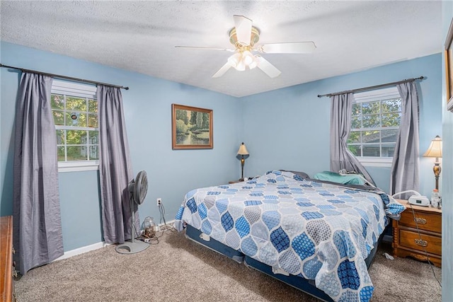 bedroom with ceiling fan, a textured ceiling, carpet, and multiple windows