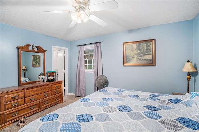 carpeted bedroom with ceiling fan and a textured ceiling