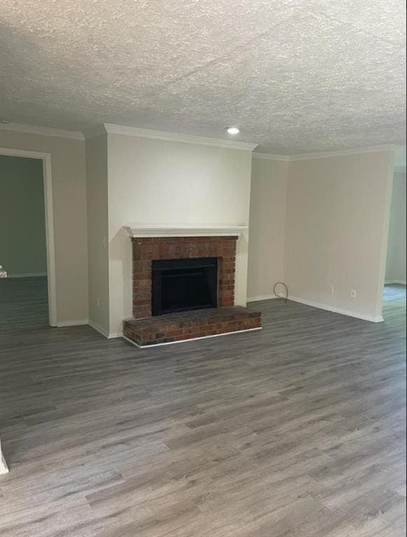 unfurnished living room with a fireplace, hardwood / wood-style floors, a textured ceiling, and ornamental molding