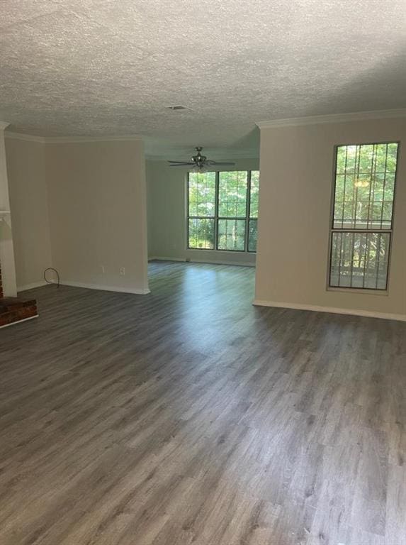 unfurnished room with dark hardwood / wood-style floors, ceiling fan, ornamental molding, and a textured ceiling