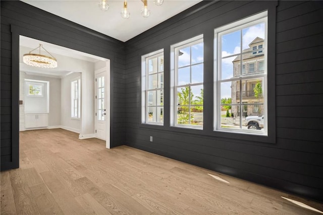 591 Brashy St, Woodstock, GA 30188 - empty room with a chandelier, light wood-style flooring, and healthy amount of natural light