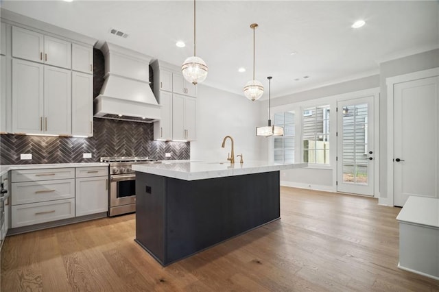 591 Brashy St, Woodstock, GA 30188 - kitchen with premium range hood, high end stove, an island with sink, a sink, and ornamental molding