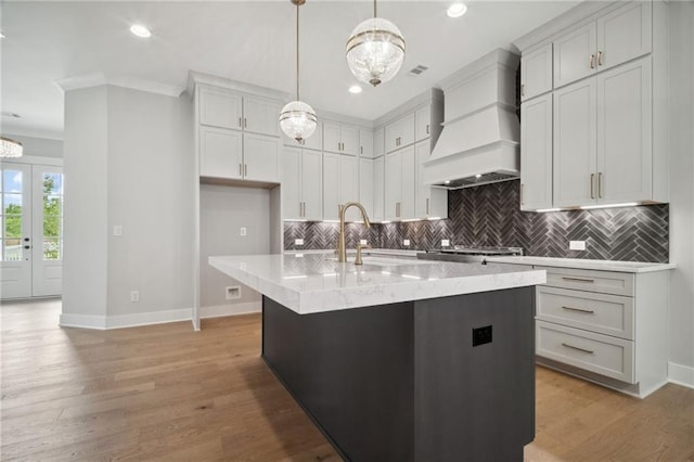 591 Brashy St, Woodstock, GA 30188 - kitchen featuring premium range hood, baseboards, decorative backsplash, ornamental molding, and a center island with sink