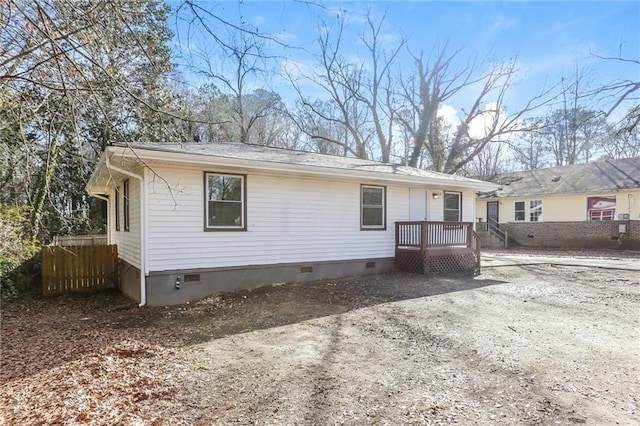 exterior space featuring driveway, crawl space, and fence