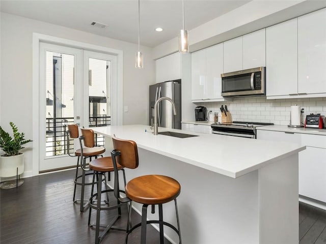 415 Gartrell St SE Unit 16, Atlanta, GA 30312 - kitchen featuring stainless steel appliances, backsplash, dark wood-style floors, a kitchen breakfast bar, and recessed lighting