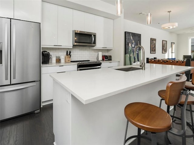 415 Gartrell St SE Unit 16, Atlanta, GA 30312 - kitchen with appliances with stainless steel finishes, dark wood finished floors, white cabinets, tasteful backsplash, and light countertops