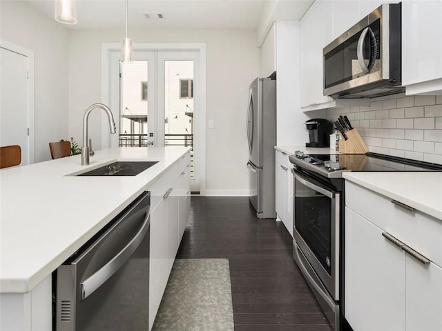 415 Gartrell St SE Unit 16, Atlanta, GA 30312 - kitchen featuring appliances with stainless steel finishes, white cabinetry, backsplash, light countertops, and hanging light fixtures