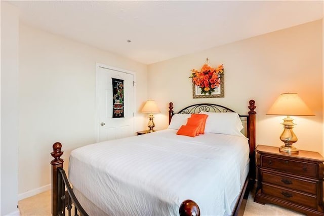 bedroom with baseboards and light colored carpet