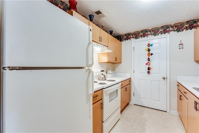 kitchen with light brown cabinetry, white appliances, light countertops, under cabinet range hood, and visible vents