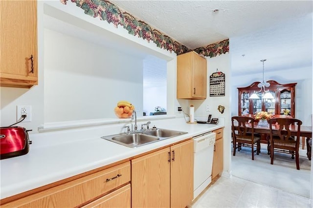 kitchen with pendant lighting, light brown cabinets, light countertops, a sink, and dishwasher