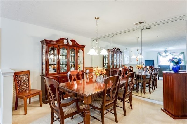 dining space featuring light carpet, a ceiling fan, and visible vents