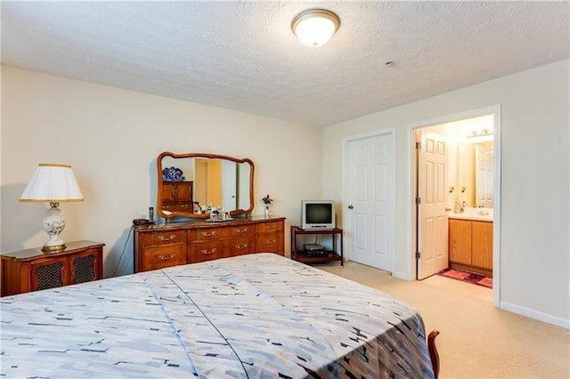 bedroom featuring connected bathroom, a textured ceiling, baseboards, and light colored carpet