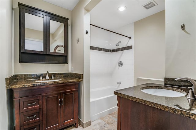 full bathroom featuring visible vents, two vanities, and a sink