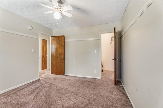unfurnished bedroom featuring a textured ceiling, baseboards, carpet, and a closet