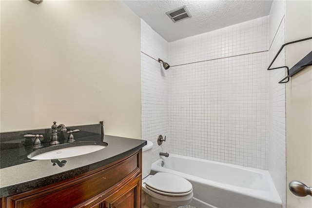 bathroom featuring vanity, visible vents, a textured ceiling, toilet, and shower / bathtub combination