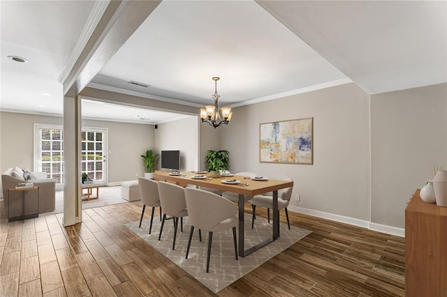 dining area with crown molding, a notable chandelier, baseboards, wood finished floors, and visible vents