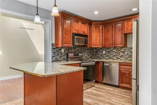 kitchen with backsplash, light wood-type flooring, a peninsula, hanging light fixtures, and stainless steel appliances