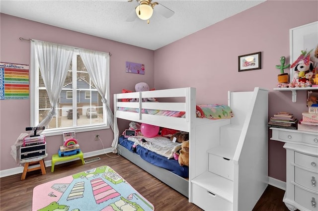 bedroom with a textured ceiling, ceiling fan, wood finished floors, and baseboards