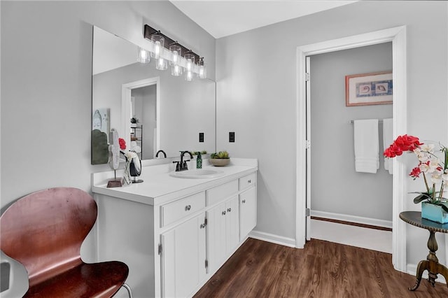 bathroom featuring wood finished floors, vanity, and baseboards