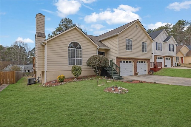 view of front of property with concrete driveway, an attached garage, fence, and a front yard