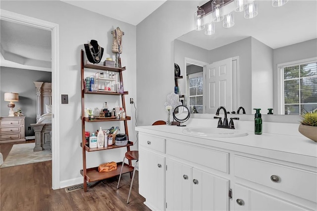 bathroom with wood finished floors, vanity, and baseboards