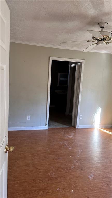 unfurnished room featuring hardwood / wood-style flooring, ornamental molding, and a textured ceiling