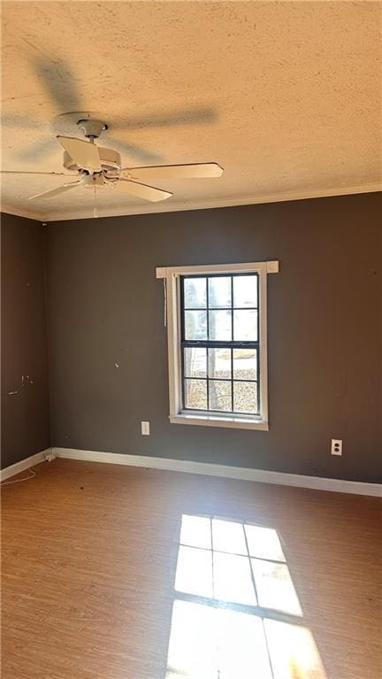 empty room featuring ceiling fan, wood-type flooring, and a textured ceiling