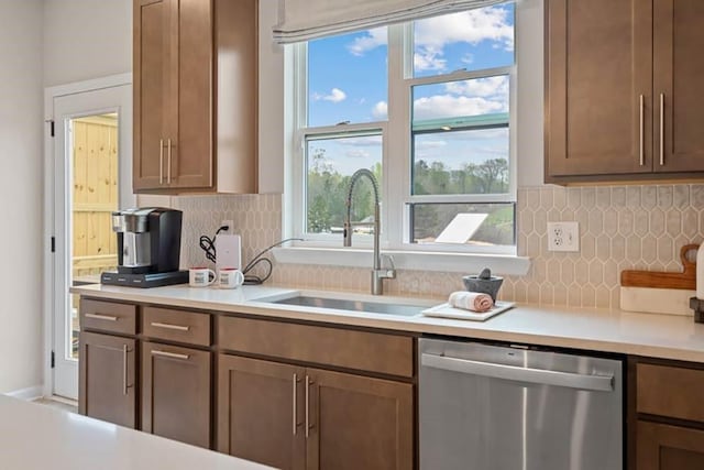 kitchen with stainless steel dishwasher, backsplash, and sink