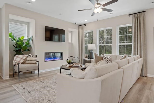 living room featuring light wood-type flooring and ceiling fan