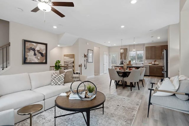 living room featuring ceiling fan and light hardwood / wood-style floors